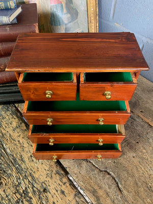 A miniature set of wooden two over three drawers