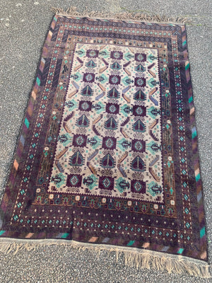 A hand woven Persian purple & turquoise ground rectangular rug