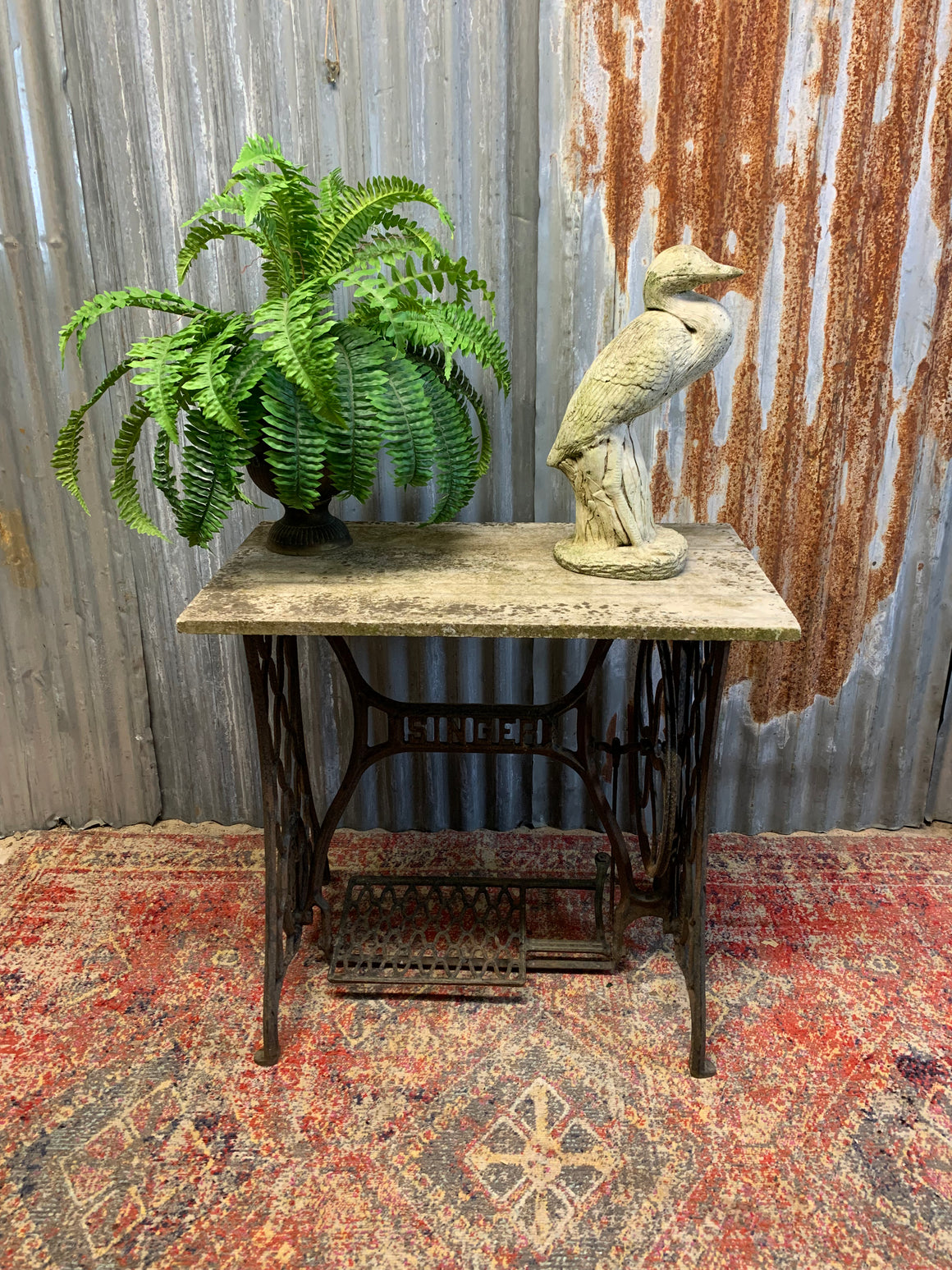 A cast iron Singer sewing table with marble top