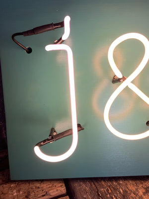 A monogrammed glass neon sign J & R
