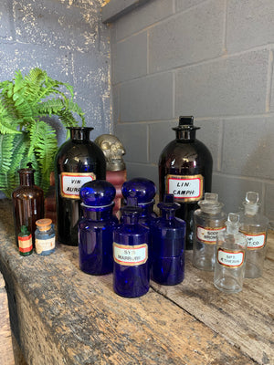 A collection of three clear glass apothecary bottles
