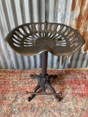 A cast iron adjustable tractor seat stool