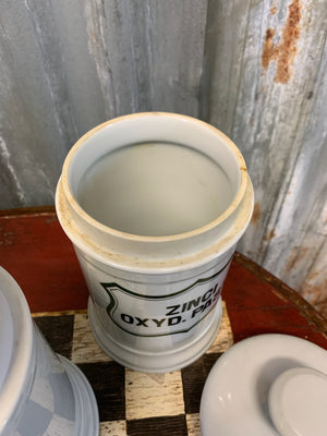 A set of three white ceramic apothecary jars