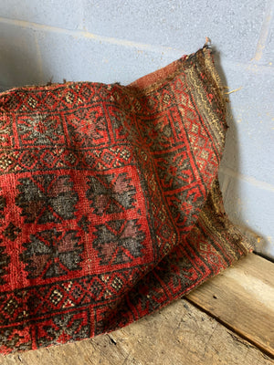A Persian red ground rectangular carpet cushion - 109cm x 52cm