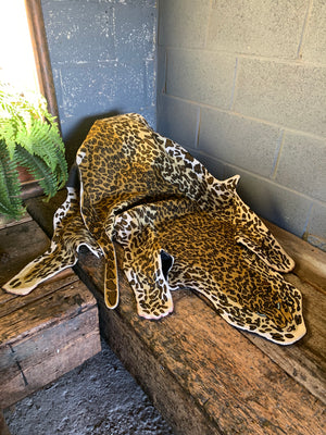 A Liberty of London faux leopard skin rug