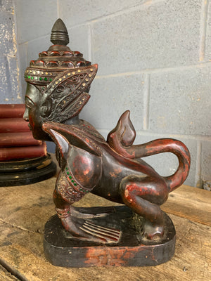 A carved wooden Manussiha sphinx statue