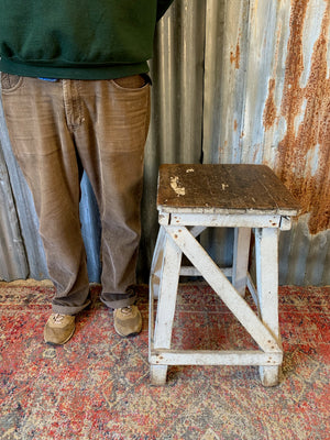 A wooden square-topped sculpture stand