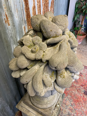 A cast stone cornucopia on plinth