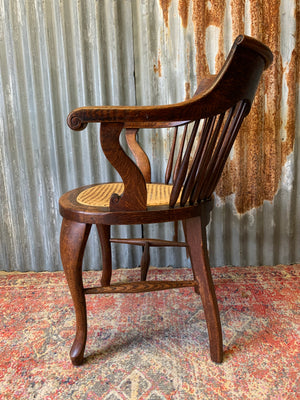 A banker's chair with caned seat