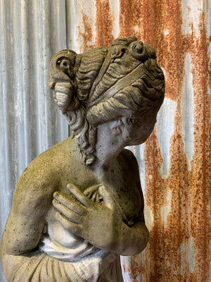 A large cast stone statue of Pandora