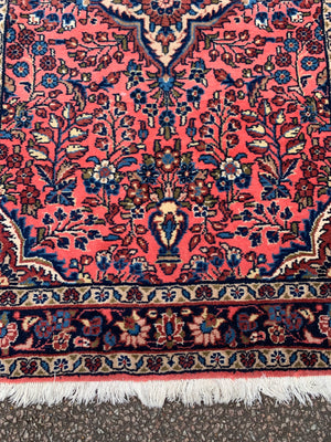 A Persian pink ground wool rug ~ 155cm x 105cm