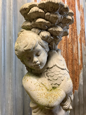 A neoclassical cast stone birdbath with cherub and fish design