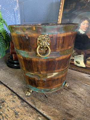 A wooden bucket with paw feet and lion head handles