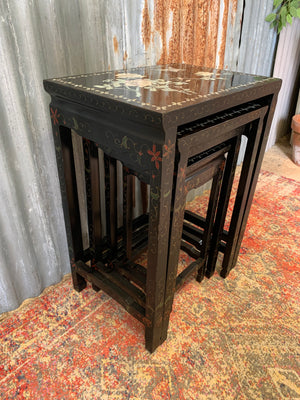 A nest of four black lacquered chinoiserie tables