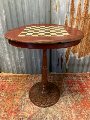 A cast iron bistro table with hand-painted chess board top