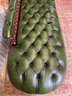 A Victorian-style green leather chaise longue