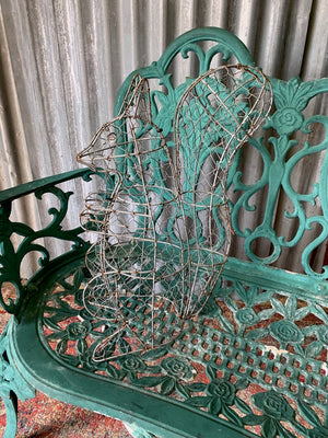 A green cast metal rose motif garden bench