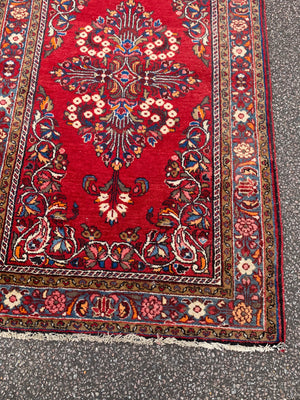 A red ground woolen Persian rug ~ 180cm x 110cm