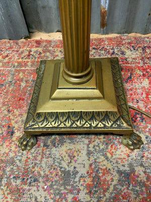 A brass Corinthian column standard lamp on lion paw feet