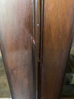 A wooden apothecary style cabinet with glass doors