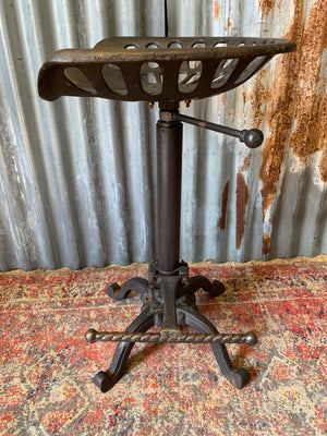 A cast iron adjustable tractor seat stool