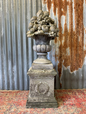 A cast stone cornucopia on plinth