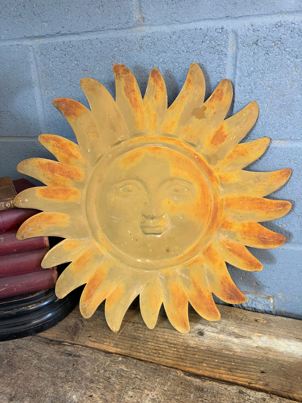 A weathered metal sunburst plaque