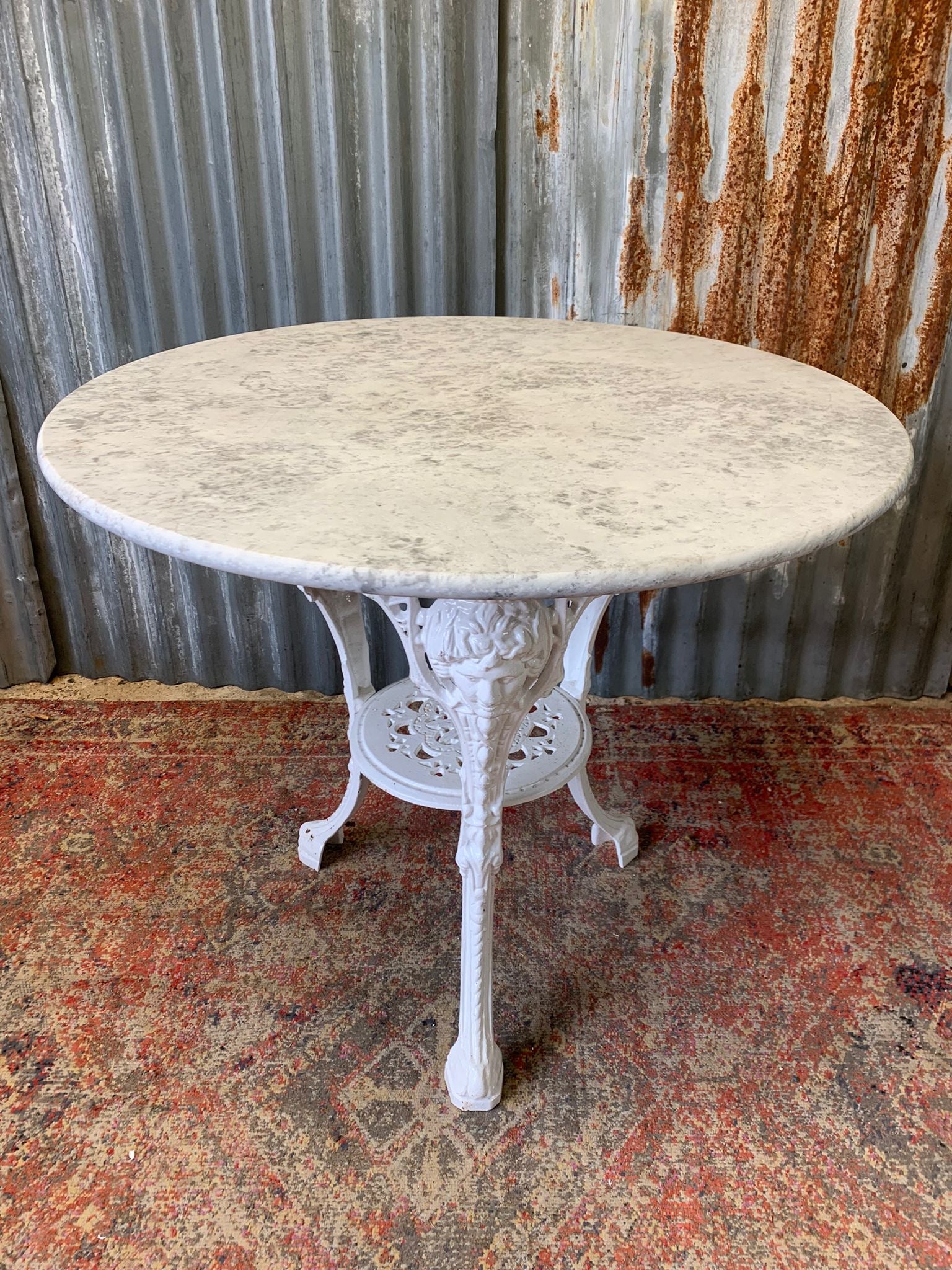 A cast iron Britannia garden table with marble top