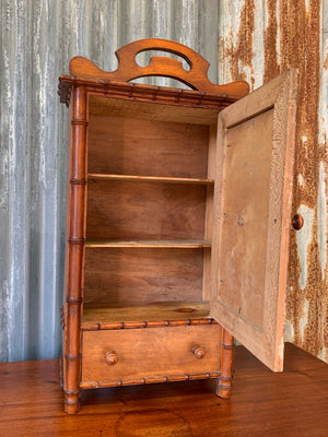 A small French faux bamboo mirrored cabinet