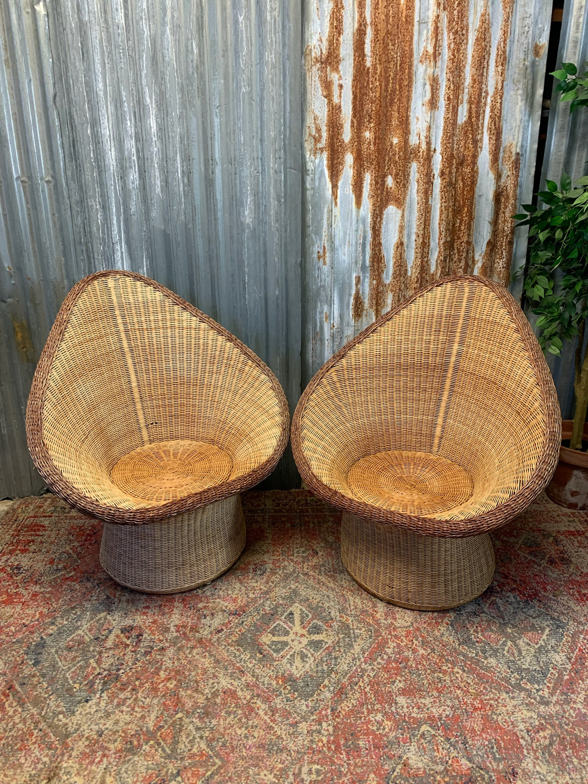 A pair of wicker egg chairs