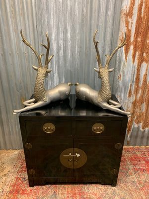 A pair of opposing white metal stags