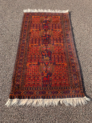 A rectangular red ground Belouch Herat rug depicting lions, camels and birds