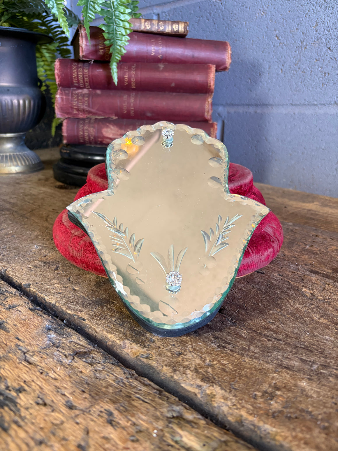 A Venetian-style mirror in the form of the Hamsa hand