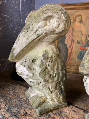 A trio of cast stone pelican statues