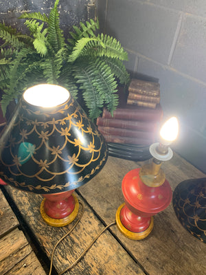 A pair of red and black toleware lamps