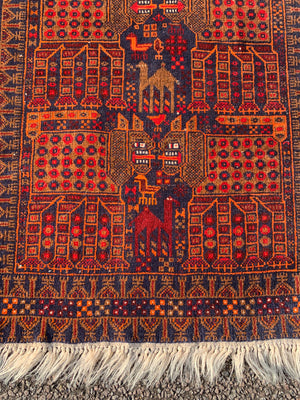 A rectangular red ground Belouch Herat rug depicting lions, camels and birds