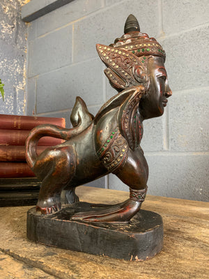 A carved wooden Manussiha sphinx statue