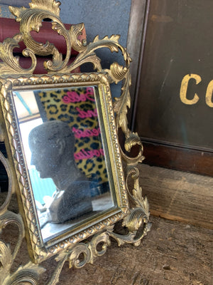 An ornate brass Rococo styled easel back mirror