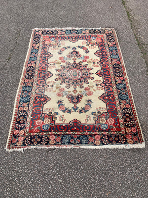 A Persian cream ground rug ~ 194cm x 133cm