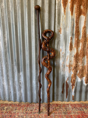 A walking stick with curling snake