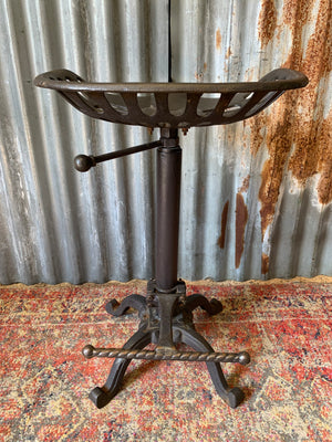 A cast iron adjustable tractor seat stool