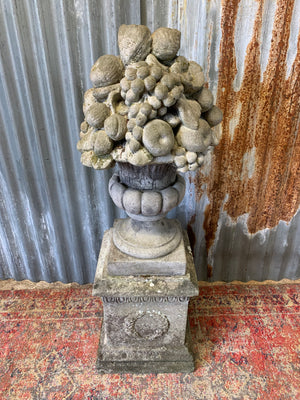 A cast stone cornucopia on plinth