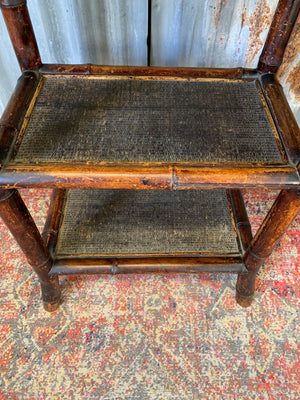 A three tier bamboo occasional table with rattan top