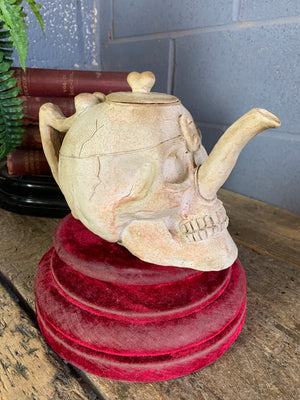 A ceramic teapot in the form of a human skull