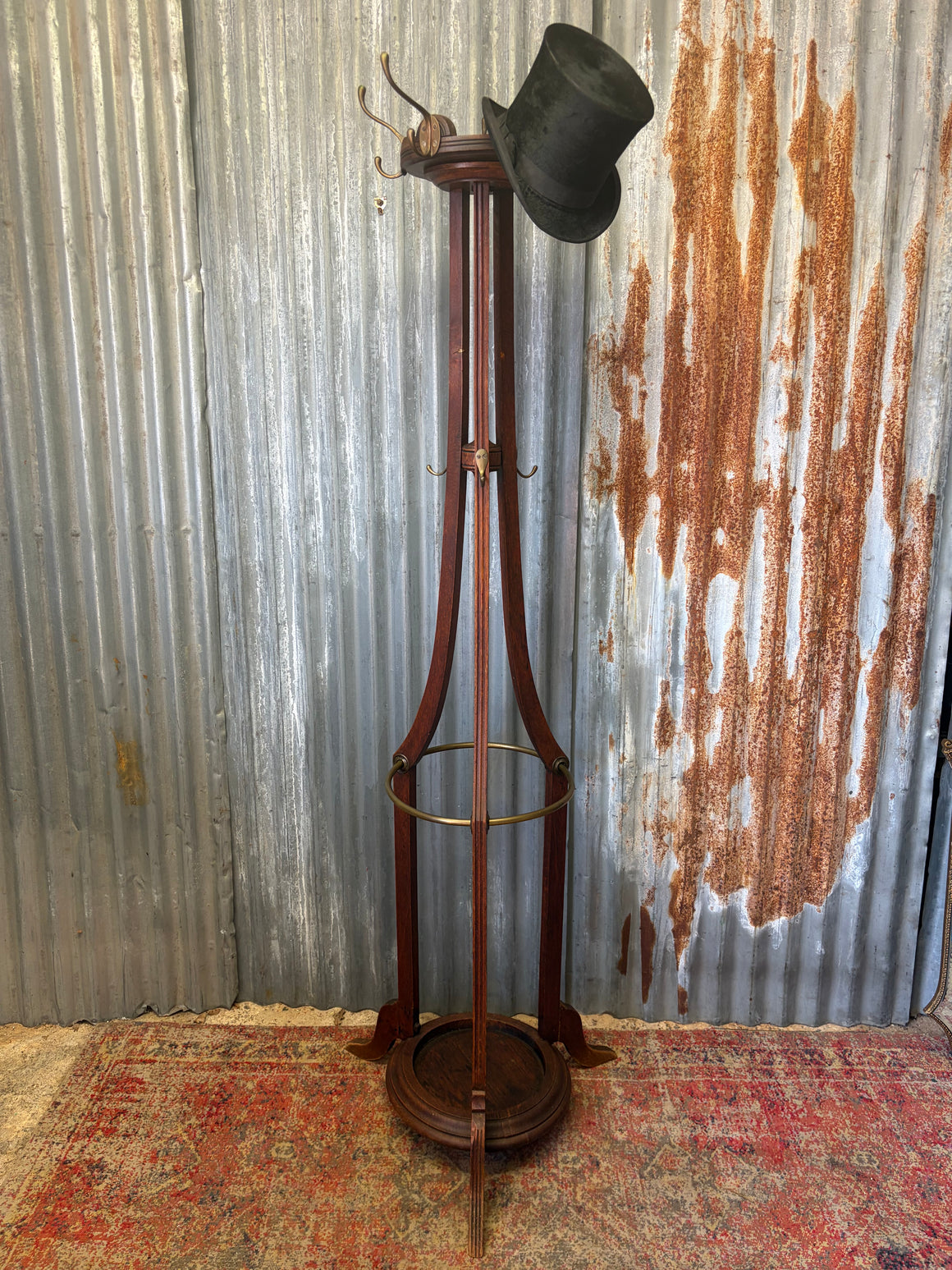 A tall oak coat stand with hat rack