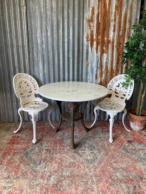 A cast iron Britannia garden table with marble top