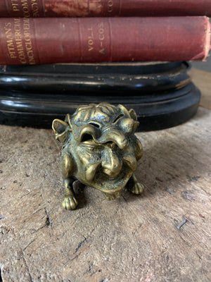 A brass inkwell in the form of an imp