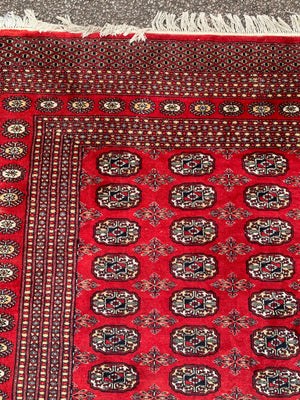 A large red ground Bokhara rectangular rug ~ 282cm x 186cm