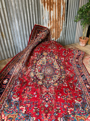 A large red ground Persian rug - 299cm x 194cm