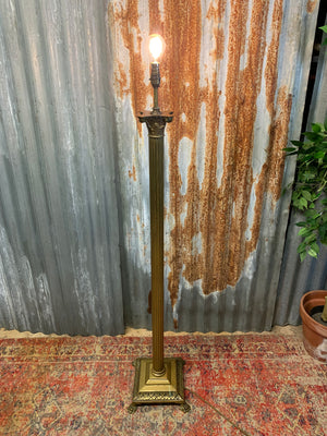 A brass Corinthian column standard lamp on lion paw feet